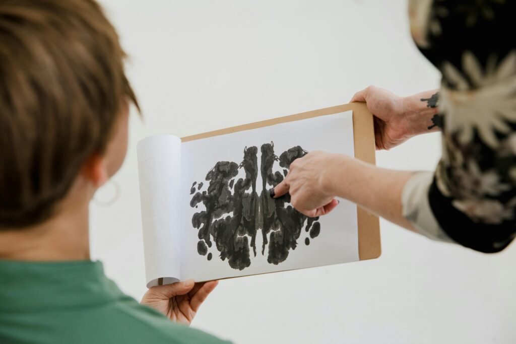 A psychologist and patient discuss a Rorschach inkblot test during a therapy session.